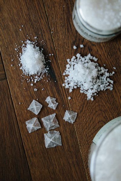 Pyramid salt crystals and flake salt arranged on dark wood